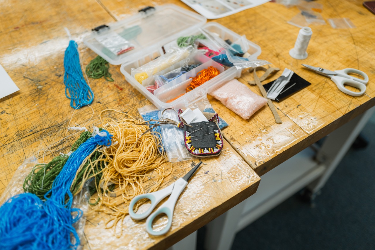 An open box of bead and jewelry supplies, with various colors and shapes.